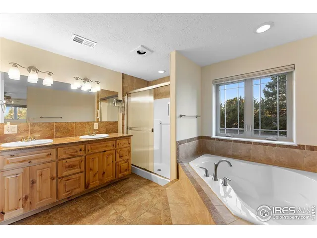 a spacious bathroom with a tub sink and mirror
