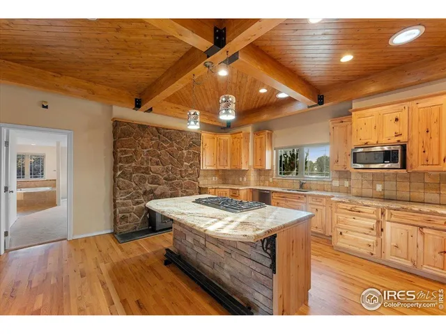 a kitchen with stainless steel appliances granite countertop a sink dishwasher and a stove with wooden floor