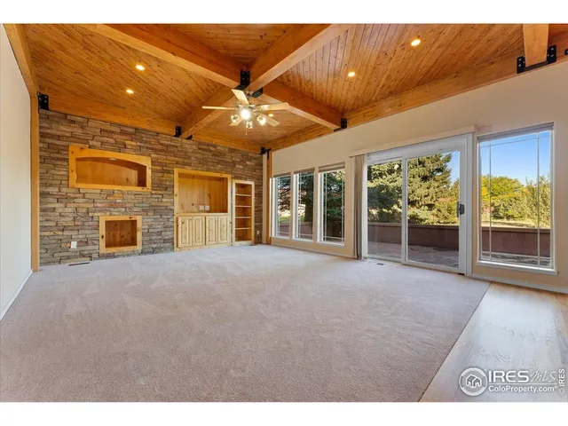 a view of an empty room with a fireplace and a window