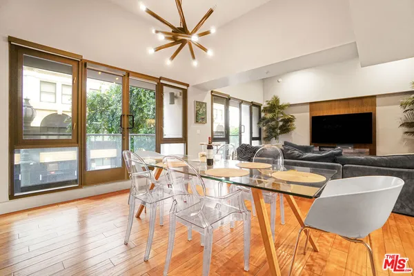 a view of a dining room with furniture a chandelier and wooden floor