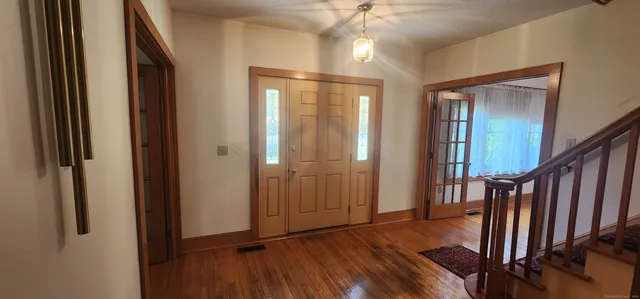 a view of a hallway with wooden floor and staircase