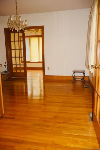 a view of empty room with window and wooden floor