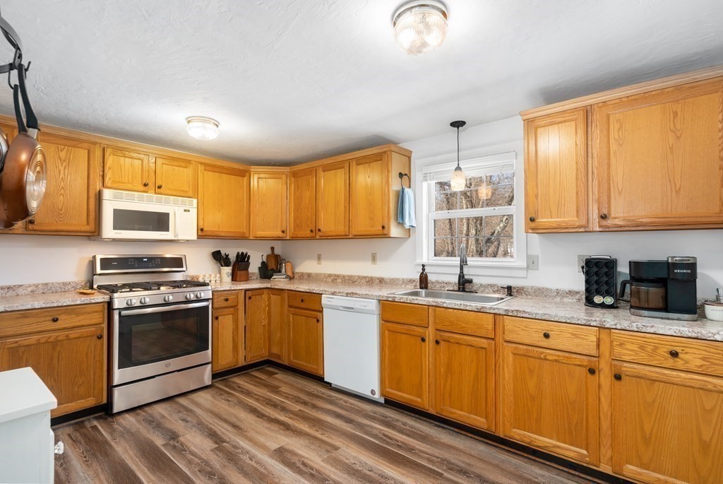 187 Freeman Road Charlton, MA 01507 - Photo 8 of 35 a kitchen with stainless steel appliances granite countertop wooden cabinets a sink a stove a refrigerator with grey cabinets and wooden floor