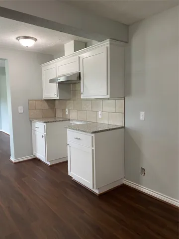 a kitchen with a sink cabinets and wooden floor