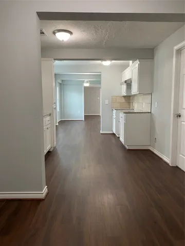 a view of a kitchen with wooden floor and a sink