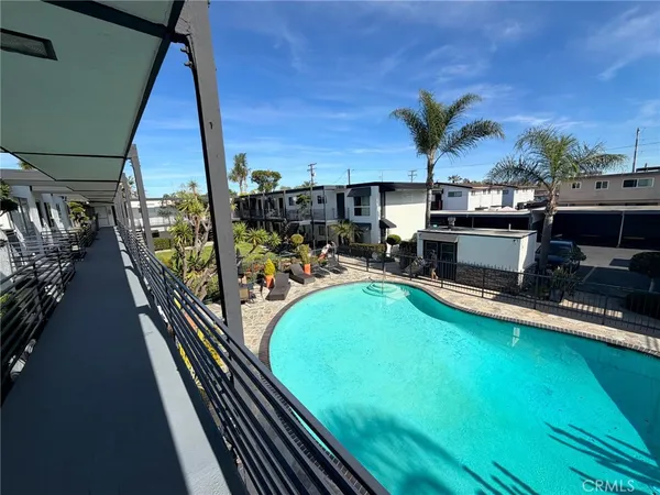 a view of a swimming pool with lawn chairs and a big yard