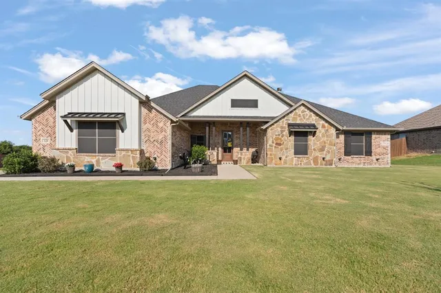 a front view of house with yard barbeque and outdoor seating