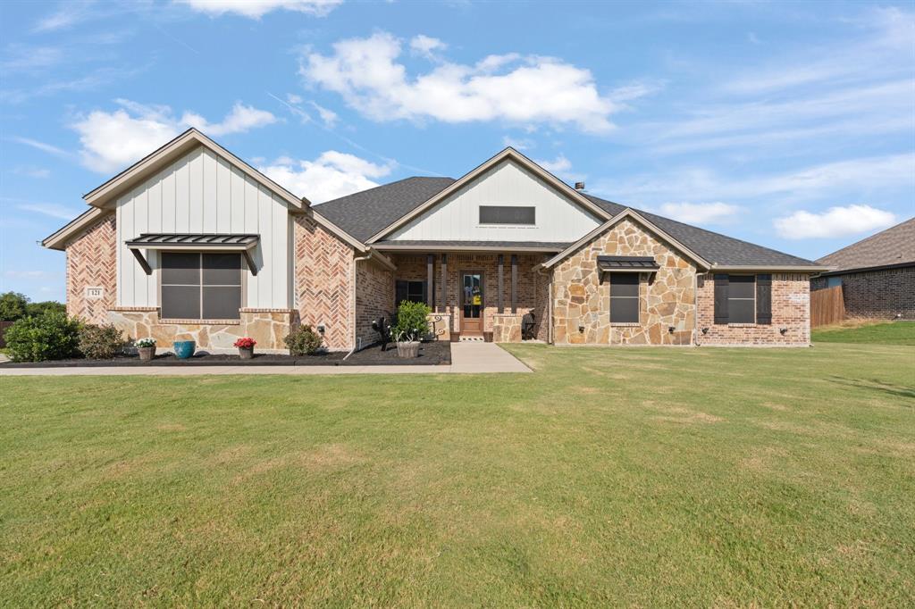 a front view of house with yard barbeque and outdoor seating
