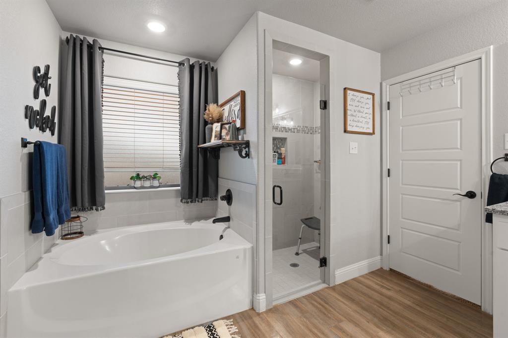 121 Treys Way Godley, TX 76044 - Photo 17 of 32 a bathroom with a bathtub and a shower
