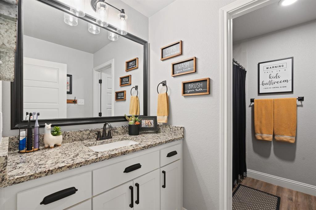 121 Treys Way Godley, TX 76044 - Photo 20 of 32 a bathroom with a granite countertop double vanity sink and a mirror