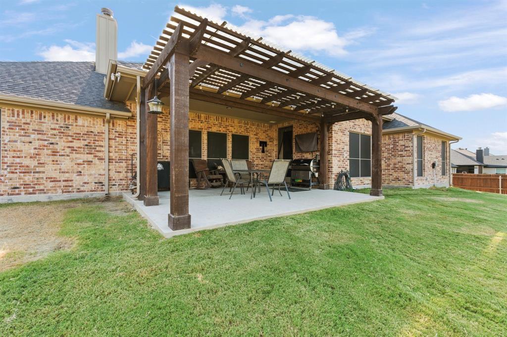121 Treys Way Godley, TX 76044 - Photo 25 of 32 a view of a patio with table and chairs and potted plants