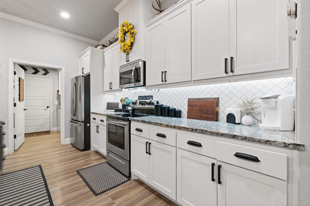 121 Treys Way Godley, TX 76044 - Photo 10 of 32 a kitchen with stainless steel appliances granite countertop a refrigerator sink and stove