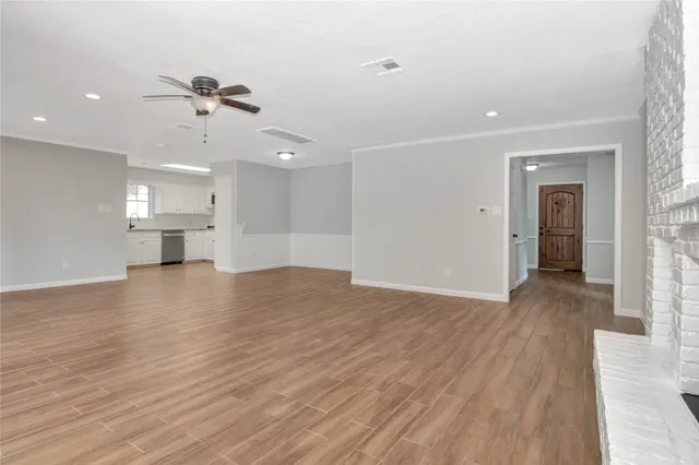 a view of empty room with wooden floor and windows