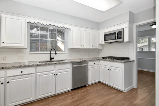 a kitchen with stainless steel appliances granite countertop a sink and a stove top oven