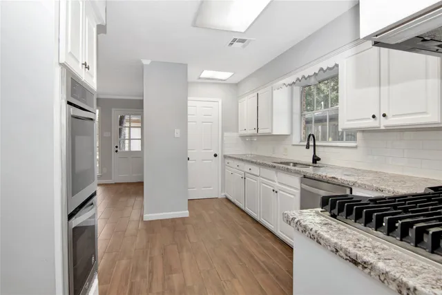 a kitchen with stainless steel appliances granite countertop a stove a sink and a refrigerator