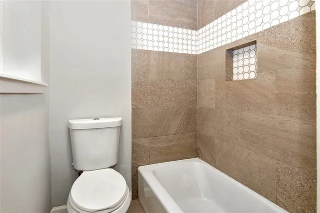 a white toilet sitting next to a bath tub and shower