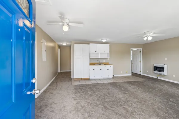 a view of a livingroom with a kitchen space a sink and a refrigerator