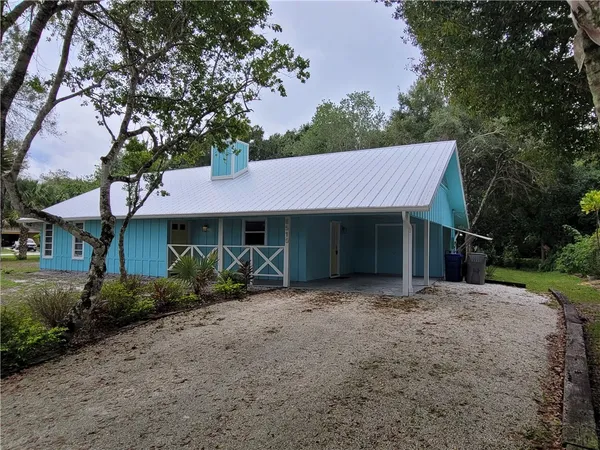 a view of a house with a yard and tree