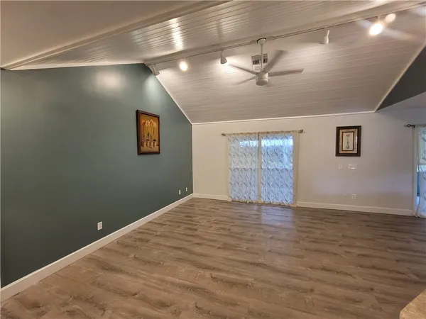 a view of empty room with wooden floor and fireplace