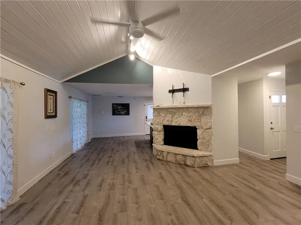 a view of empty room with wooden floor and fireplace