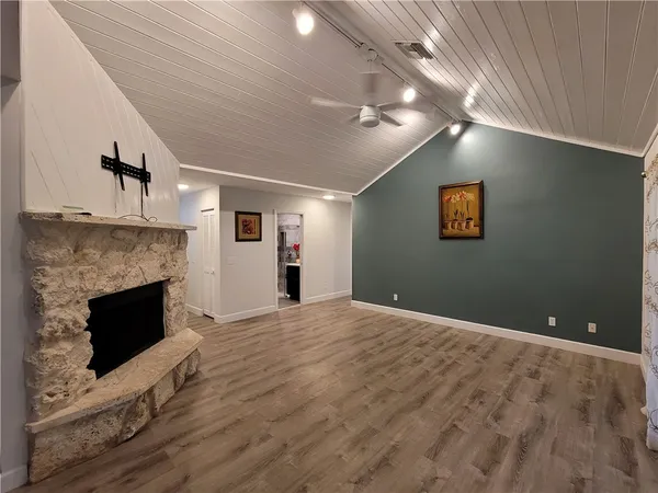 a view of empty room with wooden floor