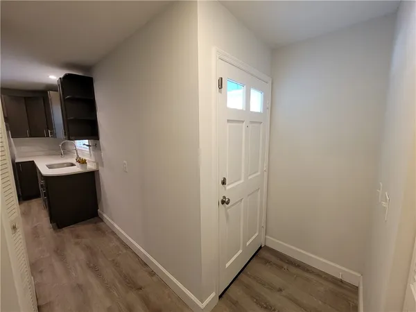 a view of a hallway with wooden floor and staircase