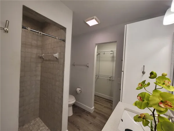 a bathroom with a sink a toilet and shower