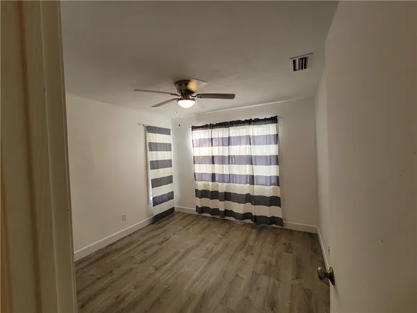 a bathroom with a granite countertop shower sink vanity and mirror