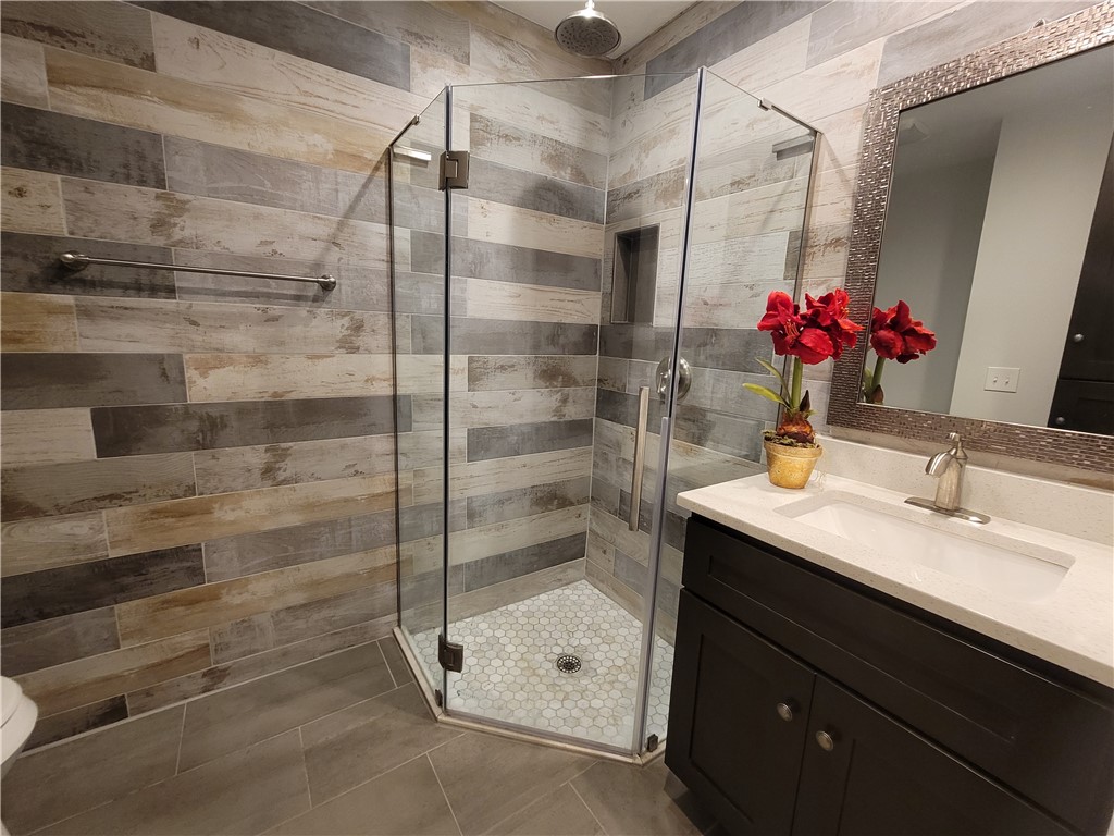 6515 5th Street Vero Beach, FL 32968 - Photo 29 of 36 a bathroom with a granite countertop shower sink vanity and mirror