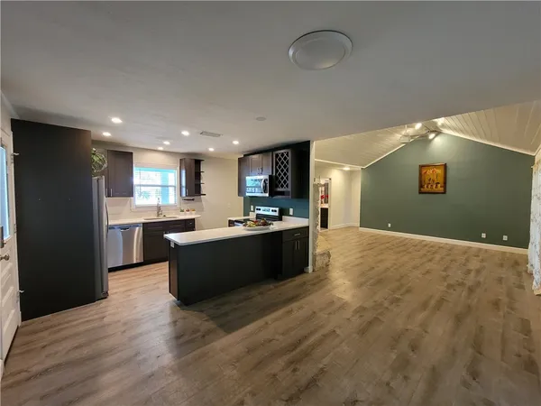 a kitchen with kitchen island a sink stove and refrigerator
