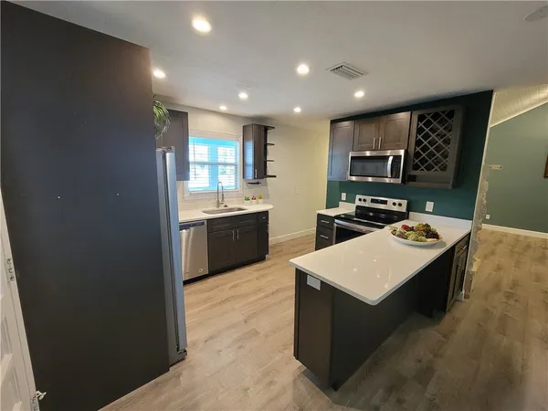a kitchen with stainless steel appliances a stove sink and cabinets