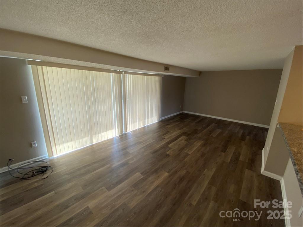 9325 Old Concord Road, Unit F Charlotte, NC 28213 - Photo 2 of 9 an empty room with wooden floor and windows