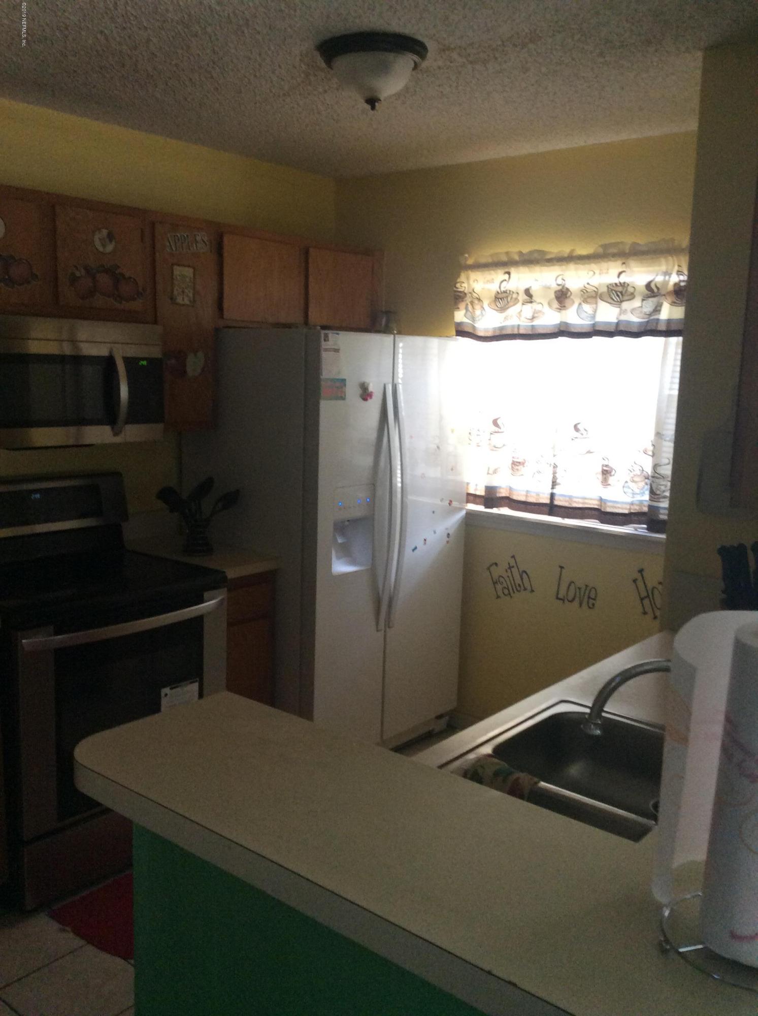 5651 Benedict Road Jacksonville, FL 32209 - Photo 3 of 4 a kitchen with a refrigerator and window