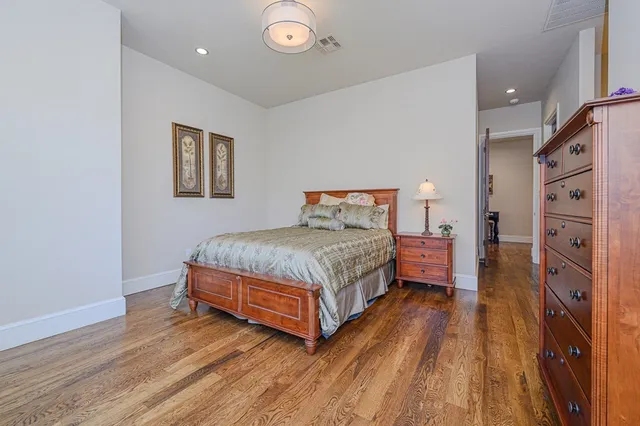 a bedroom with a bed and a large mirror on the dresser