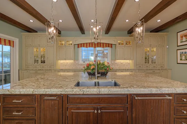 a kitchen with stainless steel appliances kitchen island granite countertop a stove and cabinets