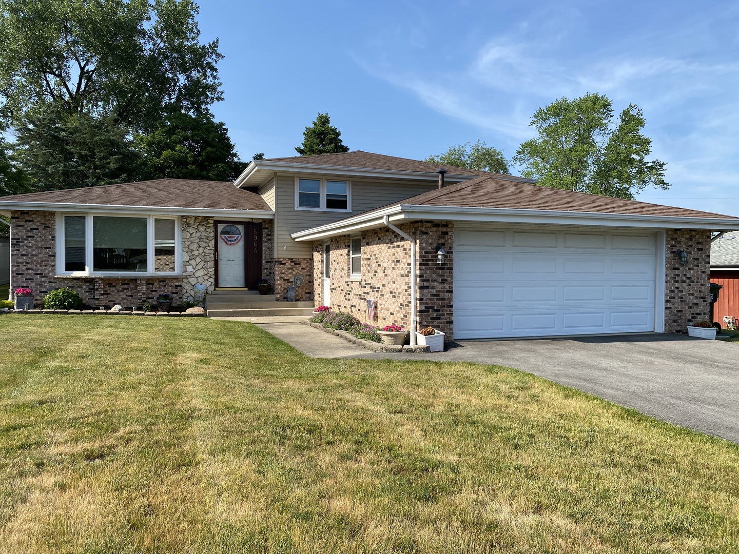 a front view of a house with a yard outdoor seating and garage