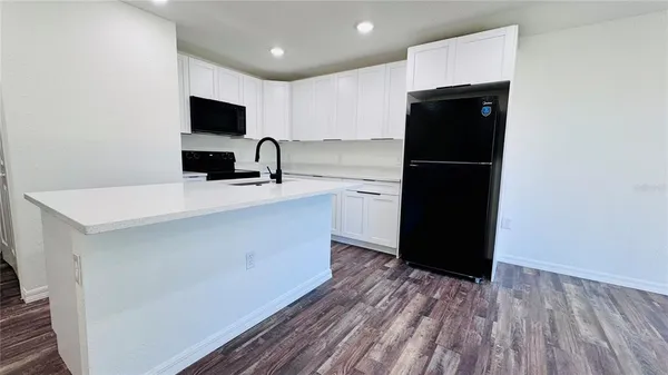 a kitchen with a refrigerator and a stove top oven