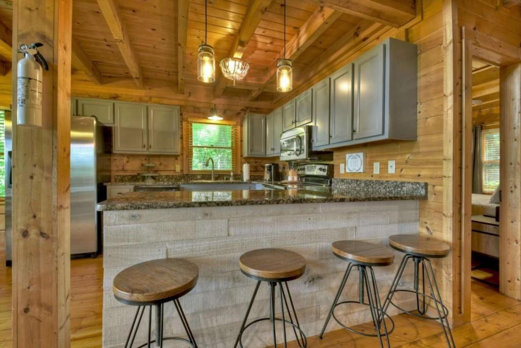 181 Ridge Circle Blue Ridge, GA 30513 - Photo 11 of 59 a kitchen with stainless steel appliances granite countertop a table chairs in it and wooden floors