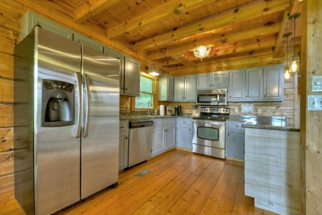 181 Ridge Circle Blue Ridge, GA 30513 - Photo 12 of 59 a kitchen with kitchen island a counter top space cabinets and stainless steel appliances