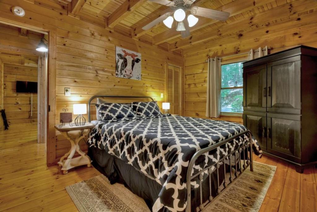 181 Ridge Circle Blue Ridge, GA 30513 - Photo 29 of 59 a bedroom with a bed and a chandelier