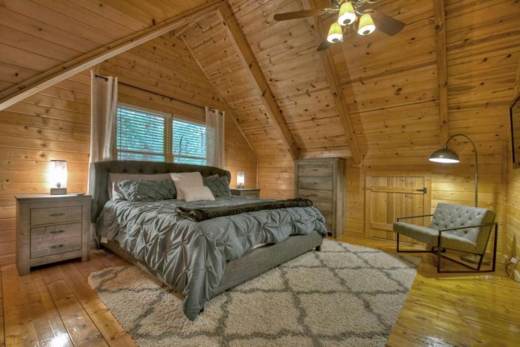 181 Ridge Circle Blue Ridge, GA 30513 - Photo 34 of 59 a spacious bedroom with a bed and a chandelier