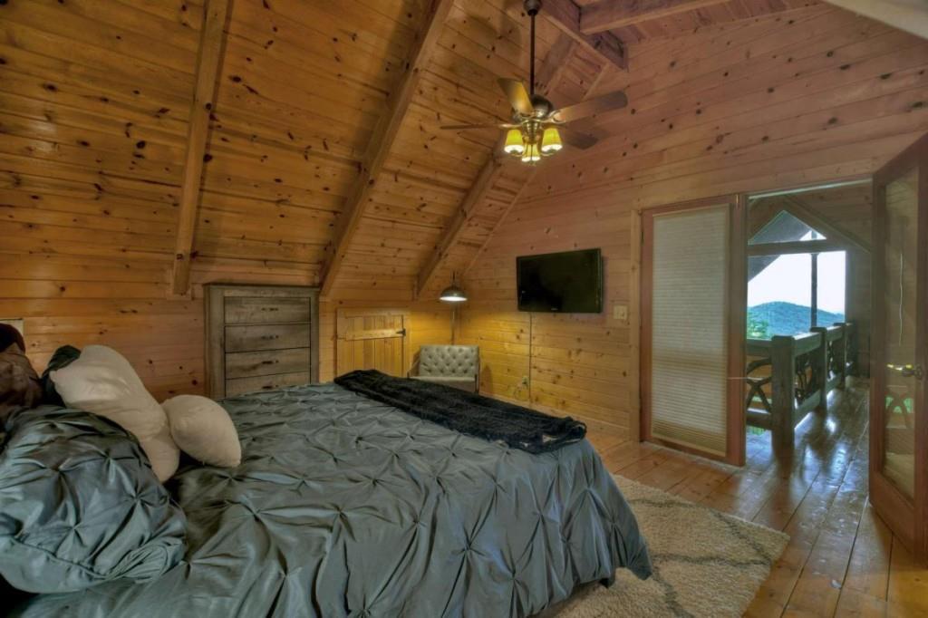 181 Ridge Circle Blue Ridge, GA 30513 - Photo 35 of 59 a spacious bedroom with a bed and a chandelier