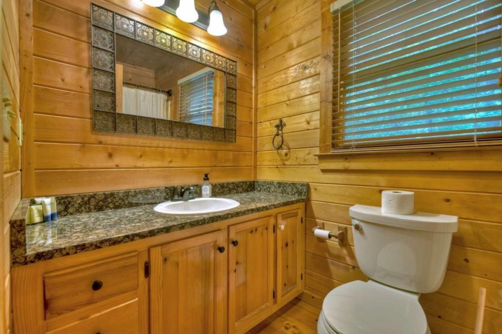 181 Ridge Circle Blue Ridge, GA 30513 - Photo 36 of 59 a bathroom with a granite countertop toilet sink and mirror