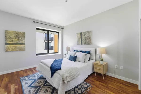 a bedroom with a bed and wooden floor