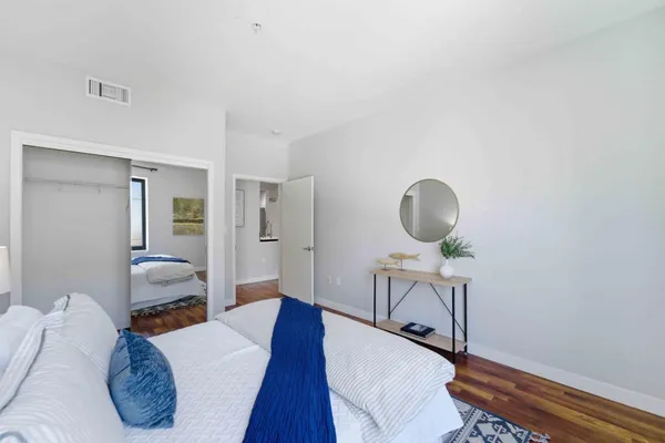 a bedroom with a bed and wooden floor