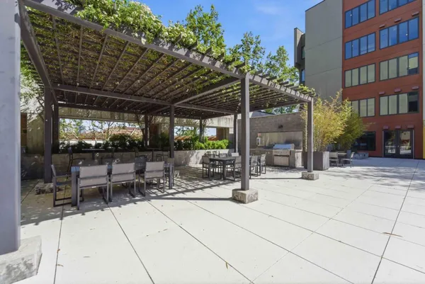a view of a patio with a table and chairs under an umbrella with a patio