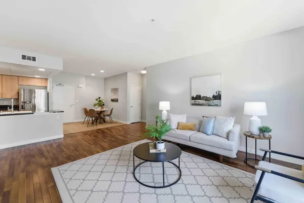 a living room with furniture a rug and a lamp