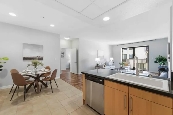 a dining hall with stainless steel appliances granite countertop a sink and a refrigerator