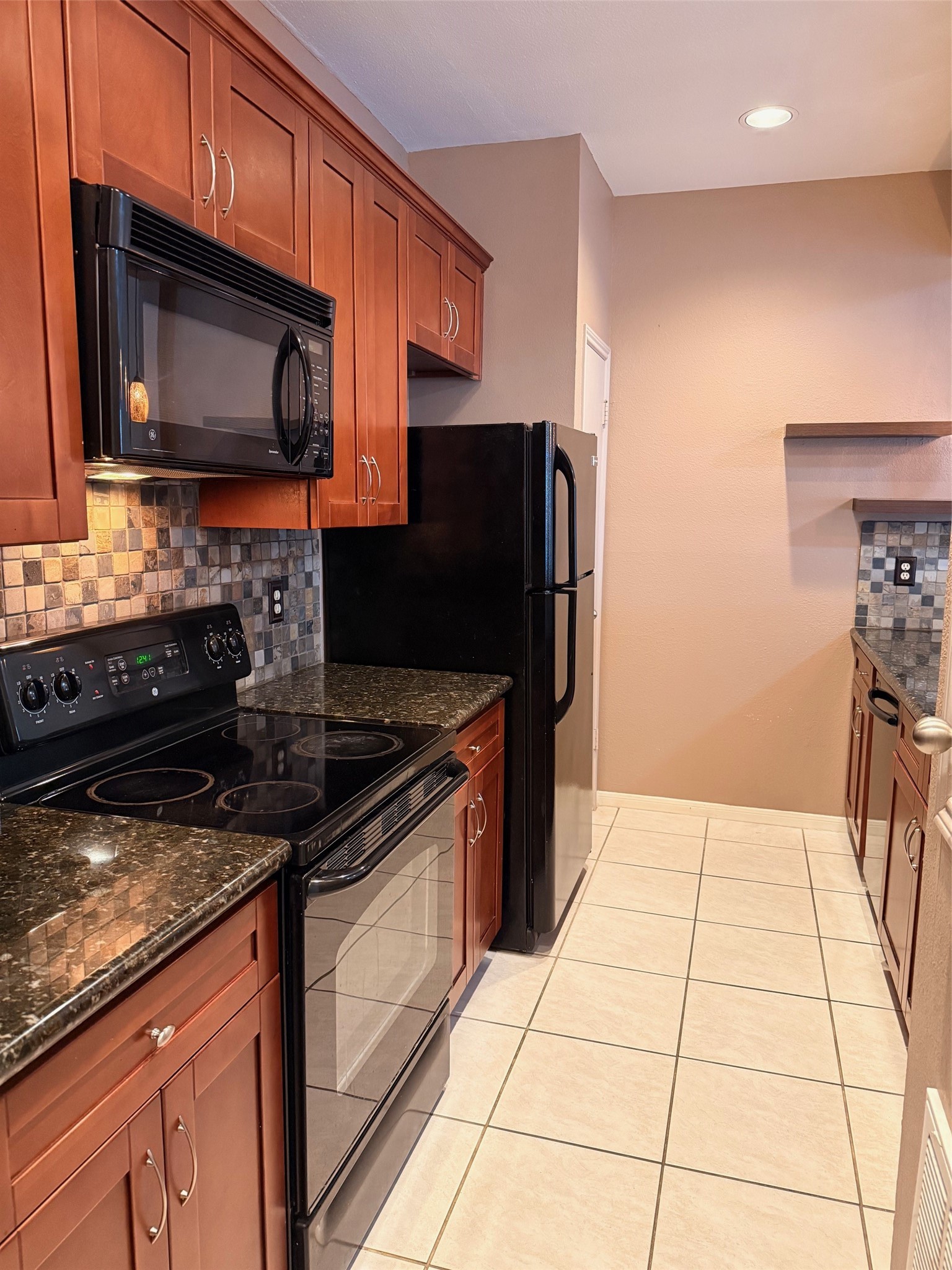 4001 Tanglewilde Street, Unit 811 Houston, TX 77063 - Photo 6 of 38 a kitchen with stainless steel appliances granite countertop a stove microwave and refrigerator