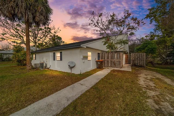 a view of backyard of house with wooden fence